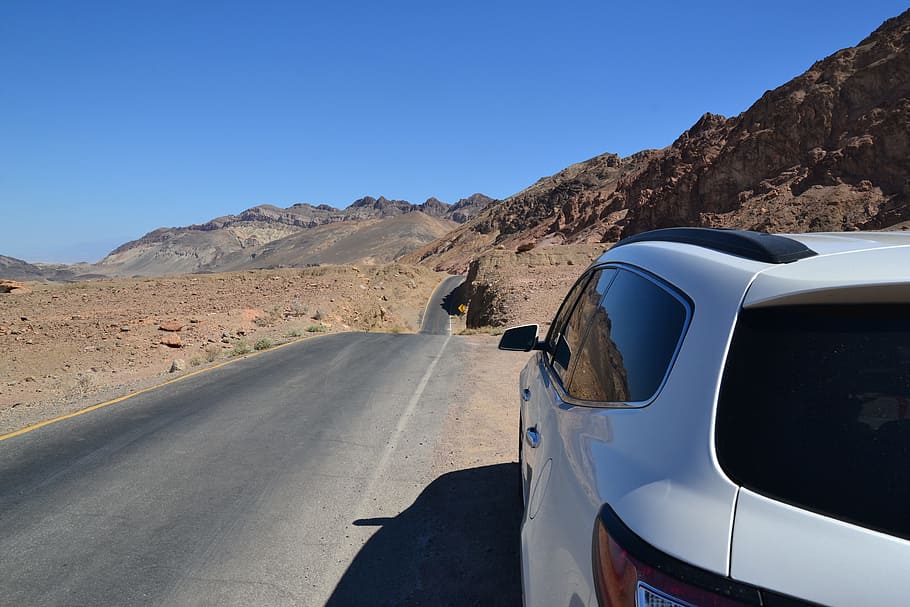 white SUV parked beside road during daytime, Paved, Hilly, Desert