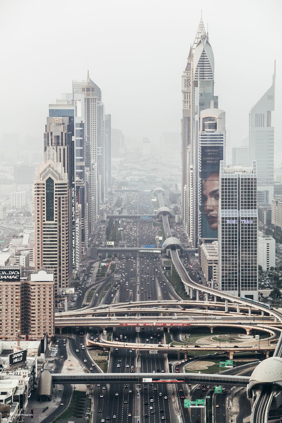 high-rise building with long winding road, cityscape covered with fog HD wallpaper