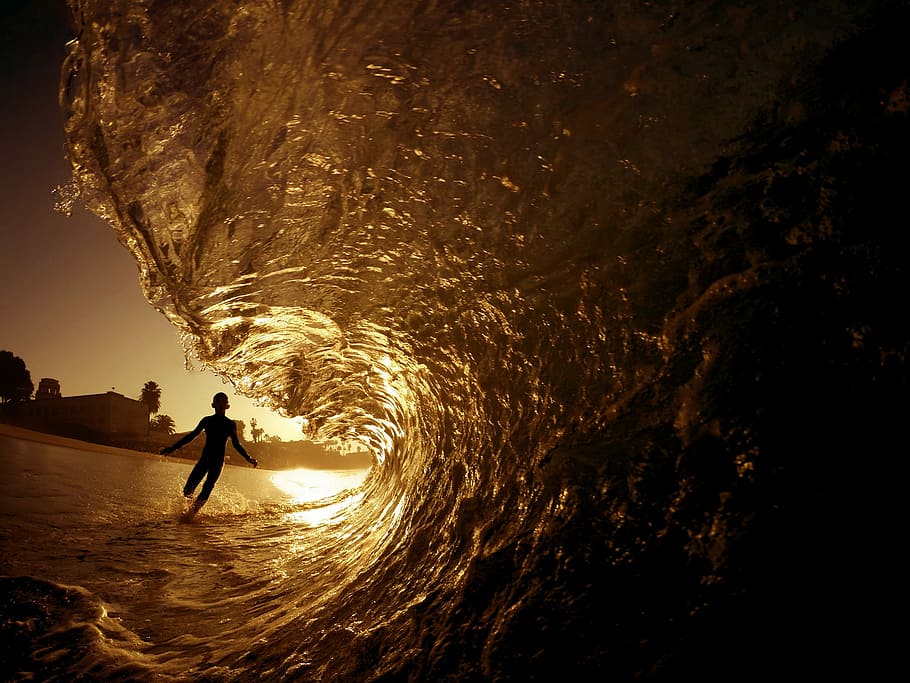 silhouette of person running towards seawave during golden hour, selective focus photography of barrel wave HD wallpaper