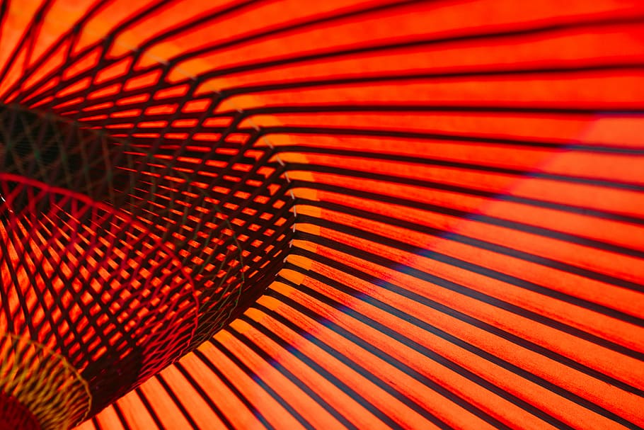 An abstract photo of orange neon lines and rails along the walls in an Asakusa building, closeup photo of red umbrella
