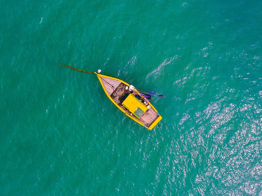 aerial view photography rowboat on body of water, bird's eyeview photo of yellow boat on body of water
