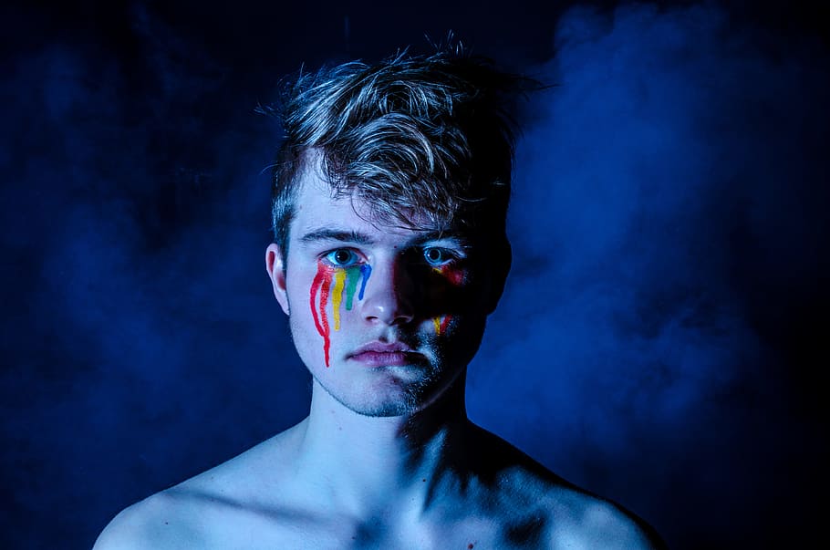 photo of man crying with colored tears, man with face painting