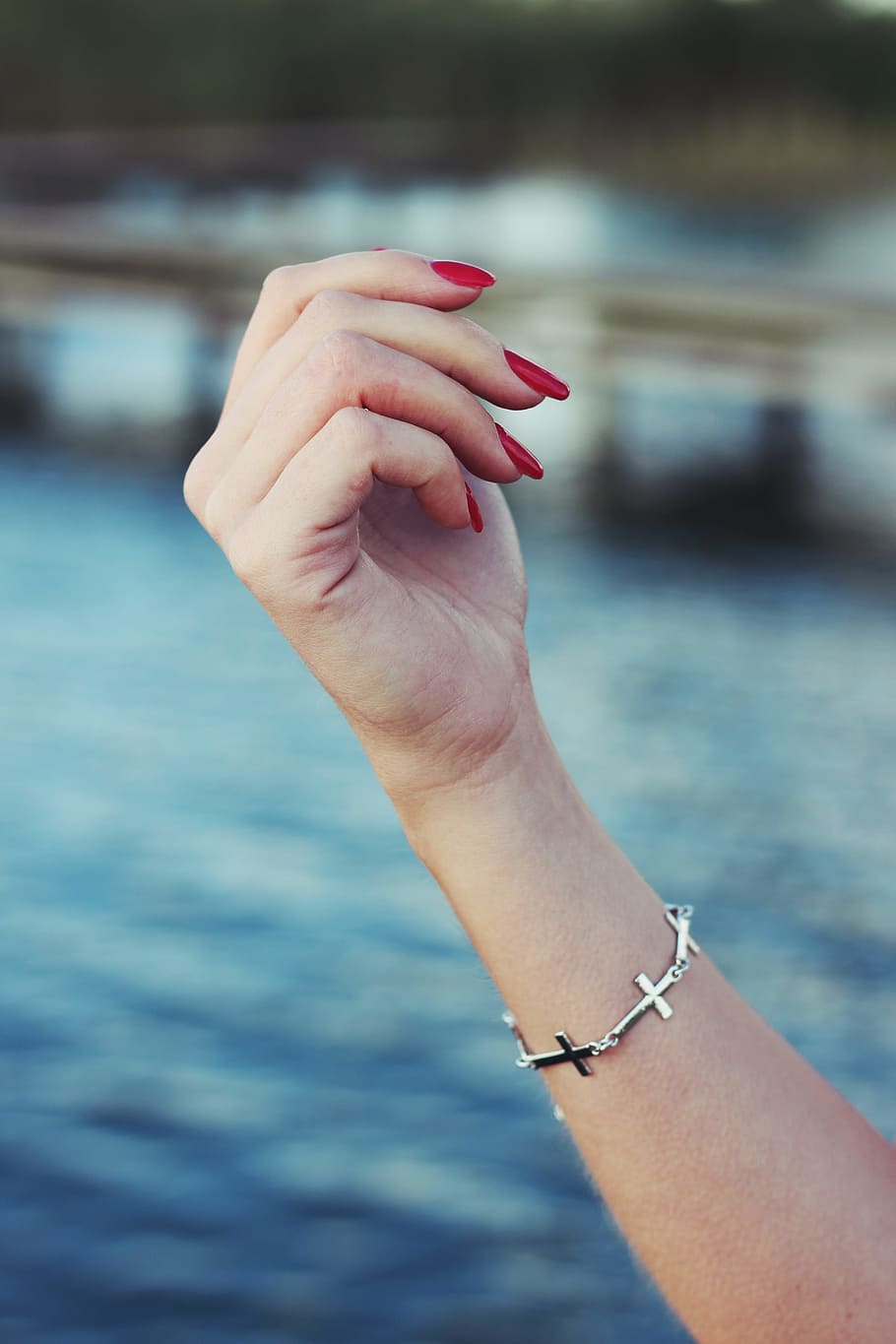 person with red manicure and silver-colored sideway cross bracelet HD wallpaper