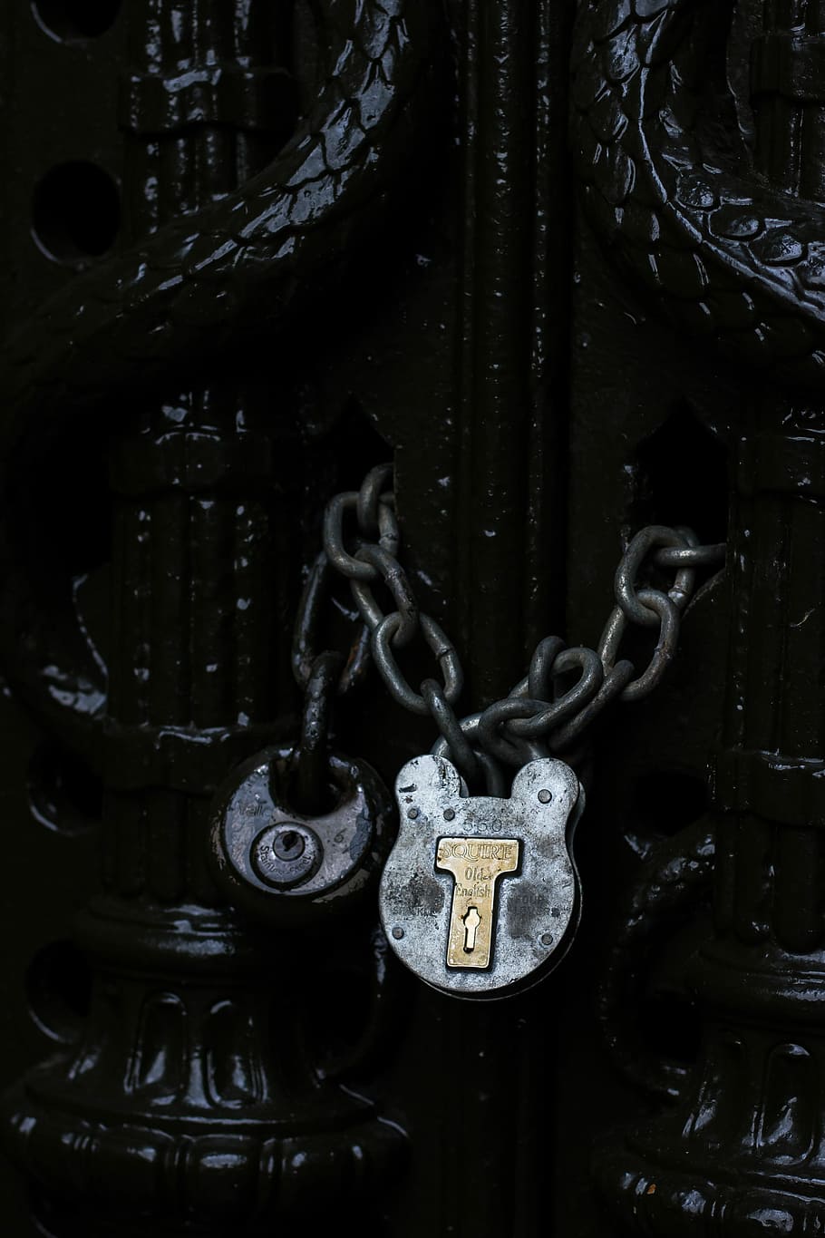 door with gray chain lock, gray padlock with chain in black gate