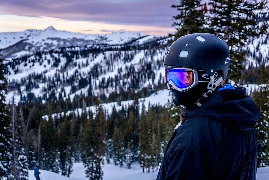 man looking sideways wearing black helmet in front of snow mountain HD wallpaper