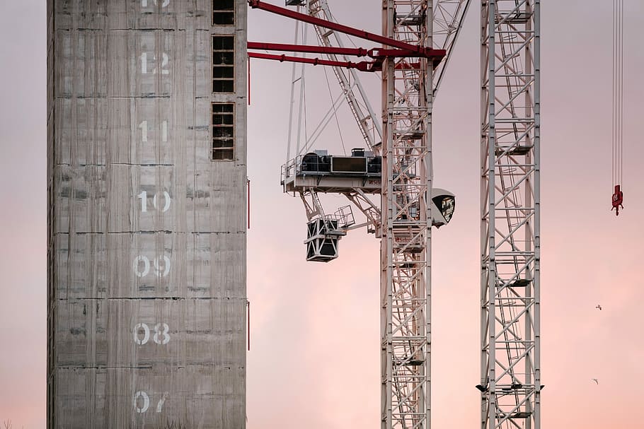 white metal crane operating beside gray concrete building at daytime, grey tower crane HD wallpaper