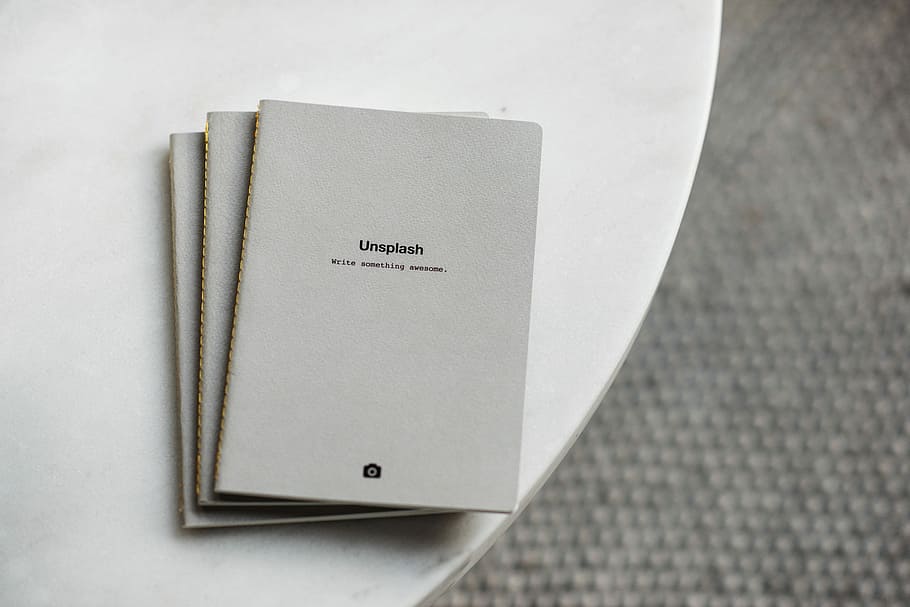 three white softbound books on white surface, three gray books on white table HD wallpaper