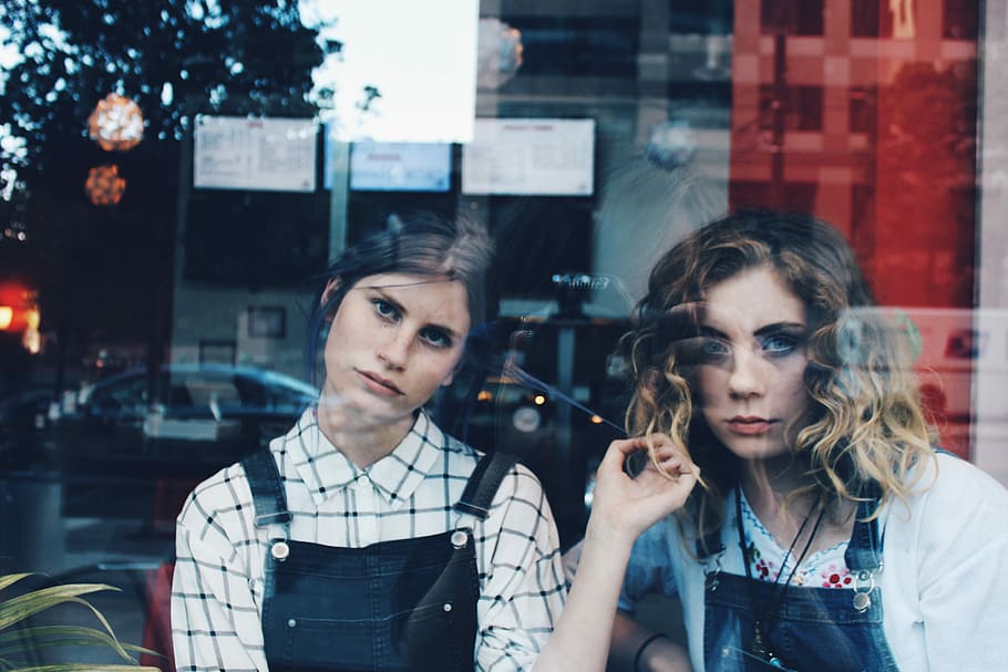 woman standing beside woman in blue dungaree, photo of two woman looking on window, HD wallpaper