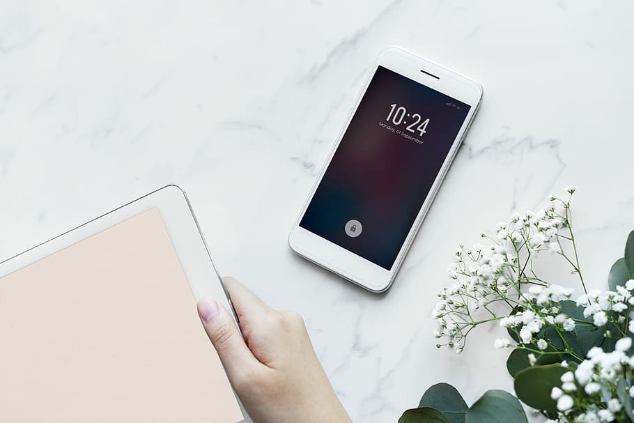 turned on white Android smartphone on white surface beside white petaled flowers HD wallpaper