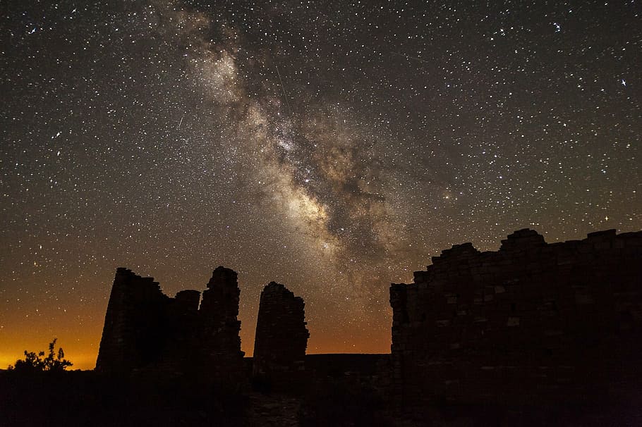 silhouette of structure during nighttime, milky way, stars, rocks
