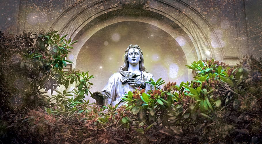 Concrete statue holding cross surrounded by green leaves, jesus, HD wallpaper