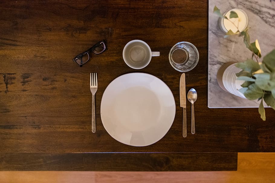 white ceramic plate on brown wooden table, flat lay photography of white plate between flatware on table HD wallpaper