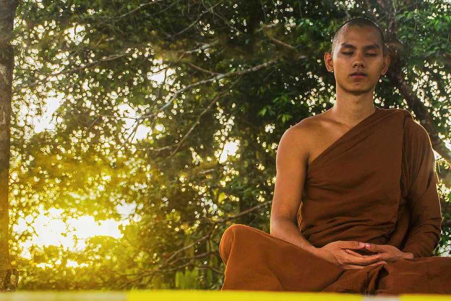 photo of man in brown kasaya robe meditating, meditate, theravada buddhism