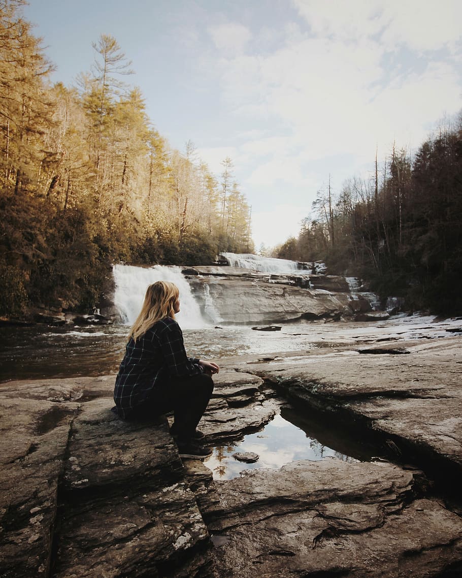 woman sitting near falls, woman sitting on rock facing waterfalls HD wallpaper
