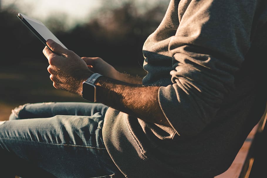person sitting on chair using tablet, person holding tablet sitting on chair HD wallpaper