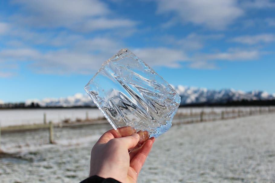 person holding clear shard under blue sky, person holding clear cut glass fragment during daytime HD wallpaper