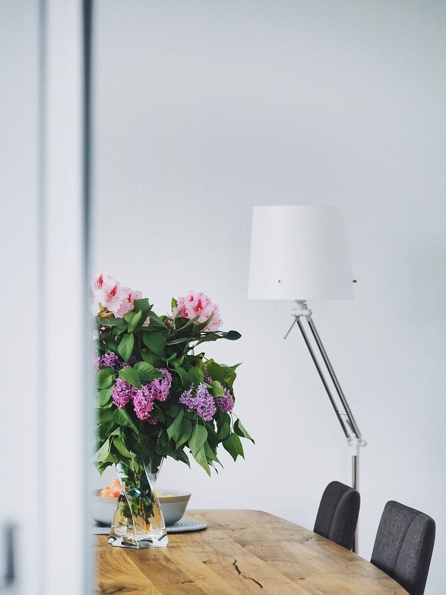 silver off-set floor lamp with white shade, purple and white flower on brown table