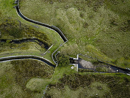 green grass field surrounding the dam, bird's eye view of lanscape HD wallpaper