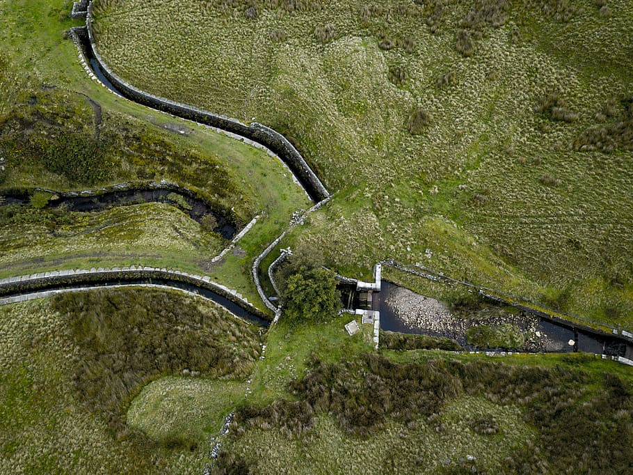 green grass field surrounding the dam, bird's eye view of lanscape HD wallpaper