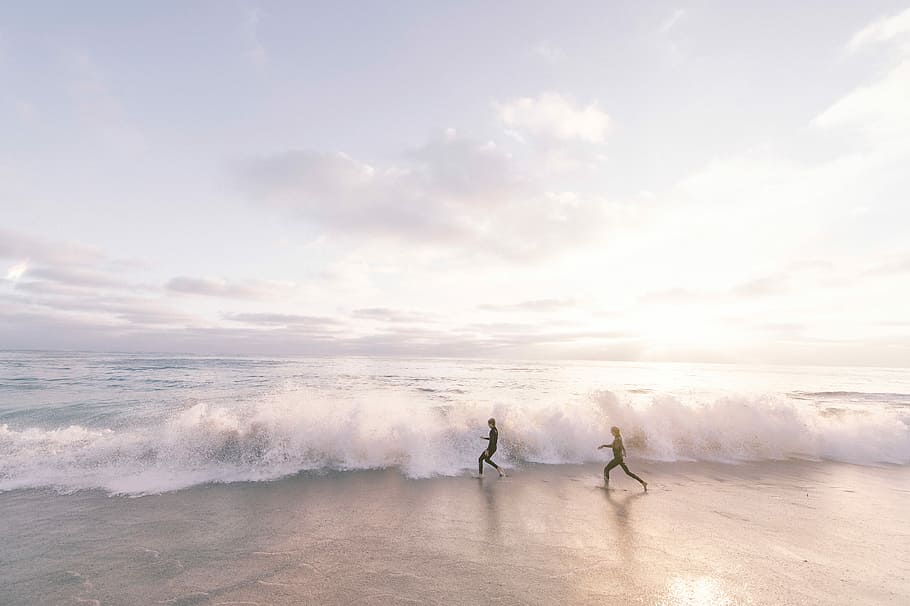 two person running on seaside beach during daytime, two persons running on seashore HD wallpaper