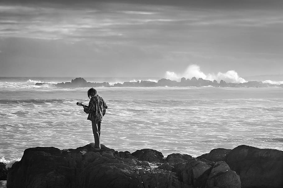 person near body of water in grayscale photography, musician