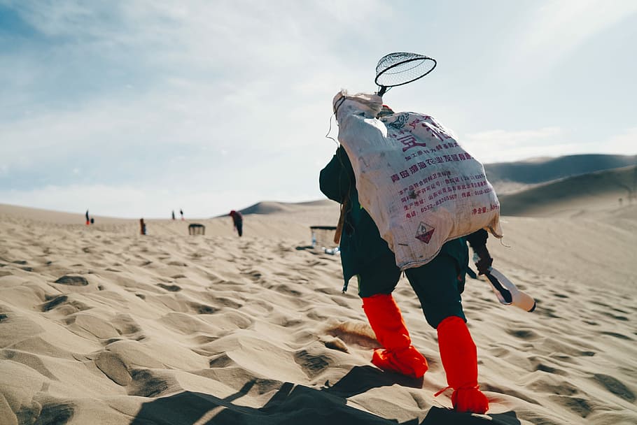 person carrying sack in the desert, person carrying a white bag HD wallpaper