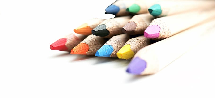 Close up picture of many colored pencil crayons on white