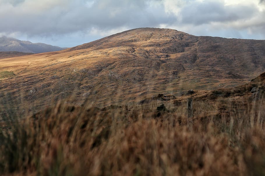 brown mountain during daytime, brown mountain under gray clouds HD wallpaper