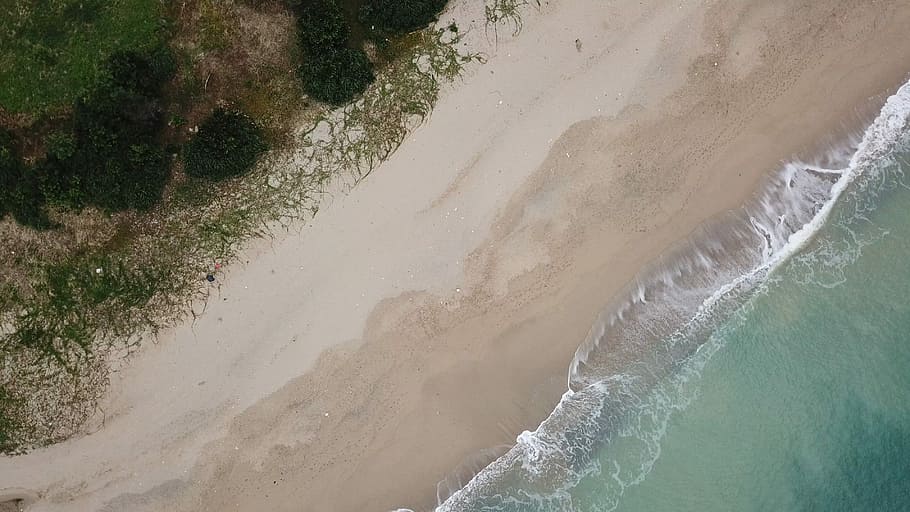 top view photography of ocean water and beach sand, aerial view