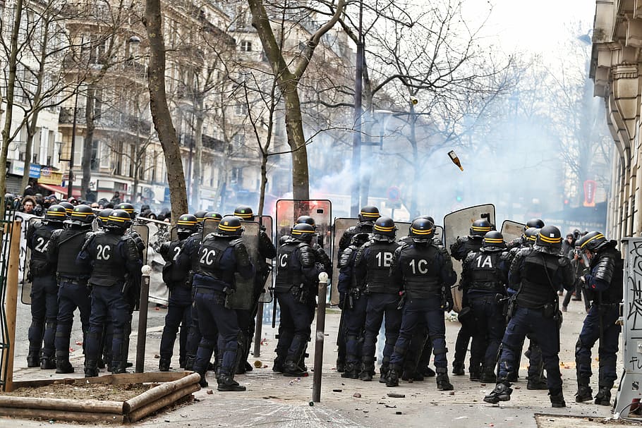 Group of police forces in uniform using riot shields for protection while  stopping activists outdoors Stock Photo - Alamy