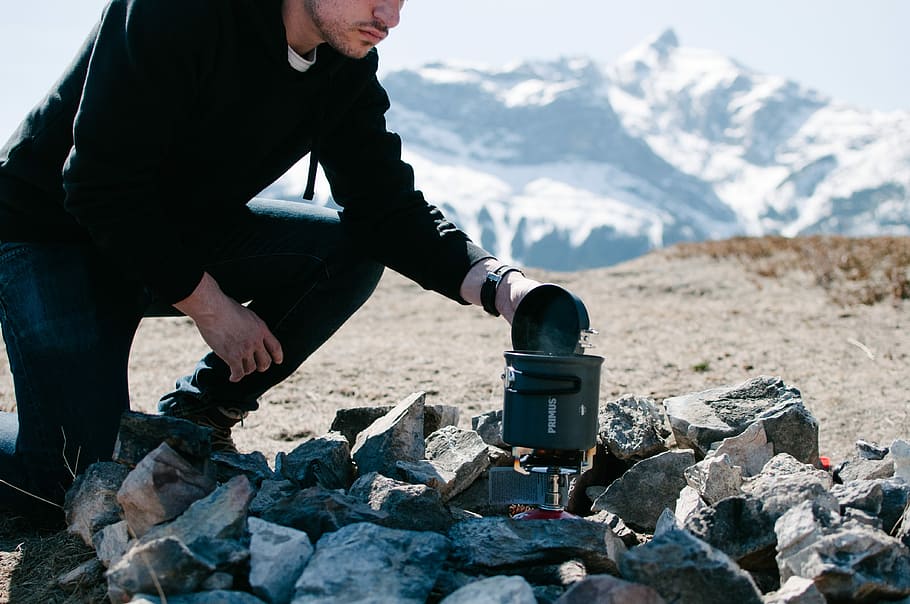 man holding device, man opening boiling portable pot, camp, rock HD wallpaper