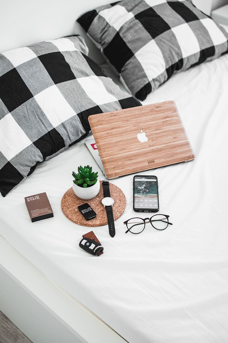 smartphone, eyeglasses, watch, and vehicle fob on bed, silver MacBook beside succulent plant and watch on top of mattress, HD wallpaper