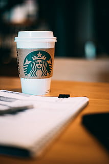 selective focus photography of Starbucks coffee cup, white Starbucks cup on brown wooden panel HD wallpaper
