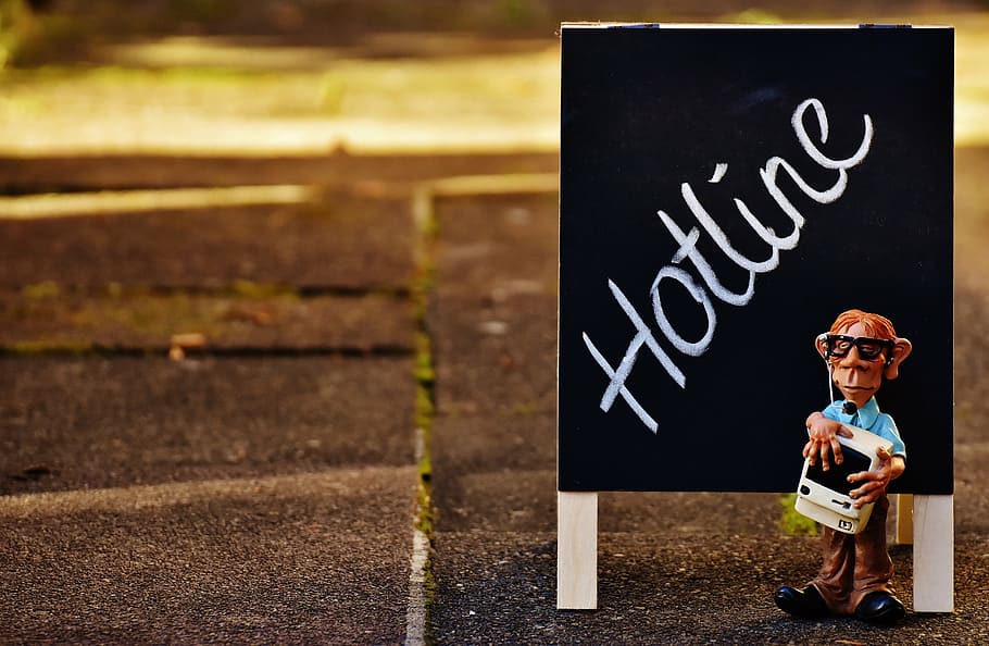 boy in blue dress shirt and brown dress pants figurine beside hotline-printed board HD wallpaper