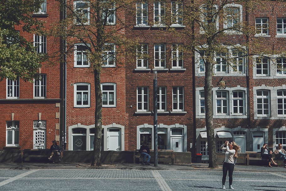 woman standing near concrete building during daytime, architecture HD wallpaper