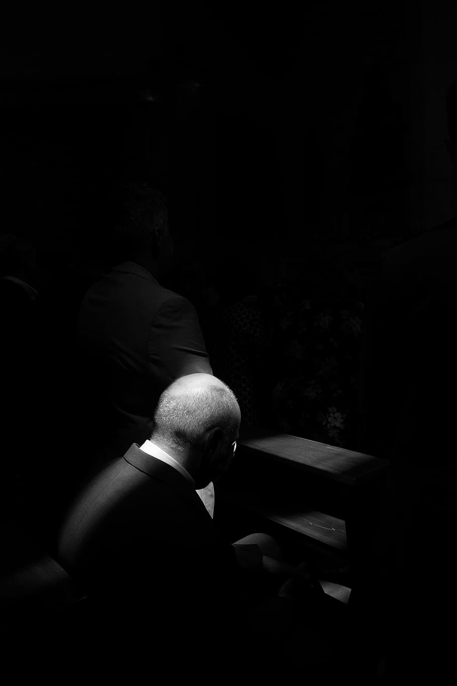 grayscale photo of man sitting on chair, grayscale photo of man sitting on pew bench HD wallpaper