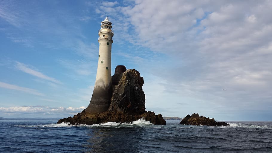white lighthouse on body of water under white clouds during daytime HD wallpaper