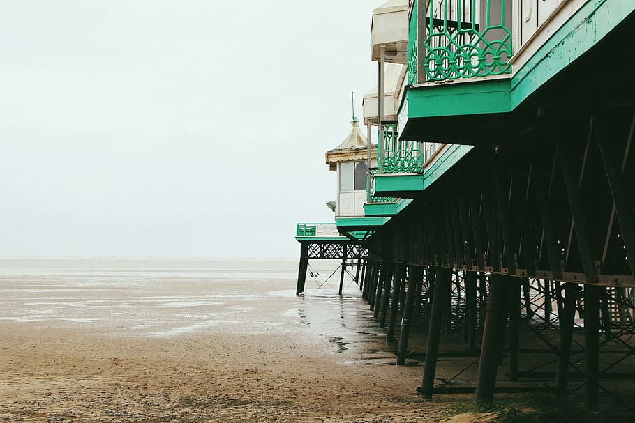 architectural photography of green and white building on seashore, wooden path on seashore HD wallpaper