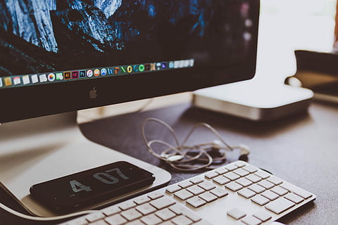 turned on thunderbolt iMac, Apple Keyboard with Numeric Number under turned on black iMac on brown wooden surface HD wallpaper