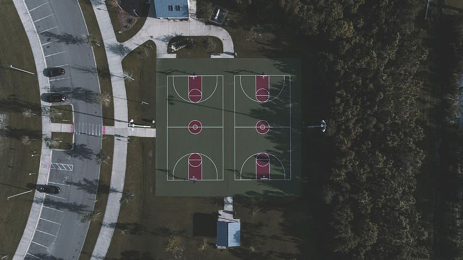 aerial view of 2 basketball courts near road, aerial view of trees
