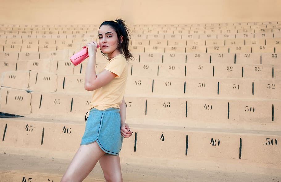 woman holding pink plastic tumbler, portrait, stadium, sport HD wallpaper