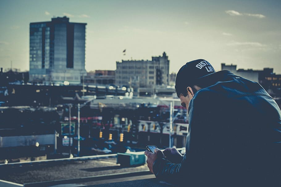 man wearing blue denim jacket looking at grey city, black, cap HD wallpaper