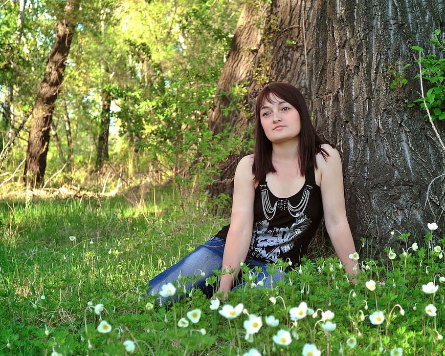 woman wearing black tank top and blue jeans sitting on grass near tree, HD wallpaper