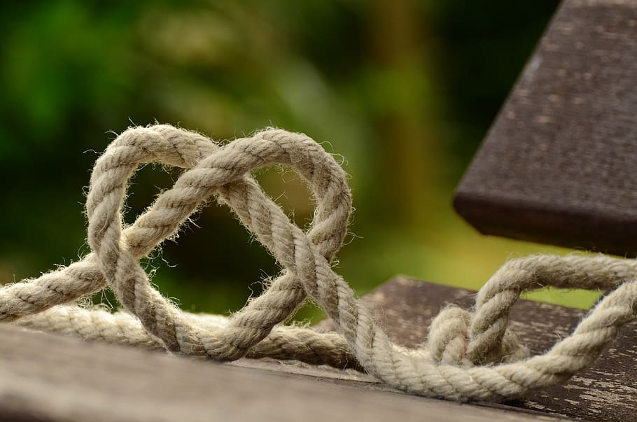 tilt lens photography of brown rope, knitting, heart, love, together