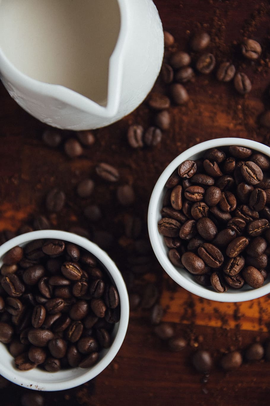 black coffee beans in ceramic mugs, two cups of coffee beans beside pitcher HD wallpaper