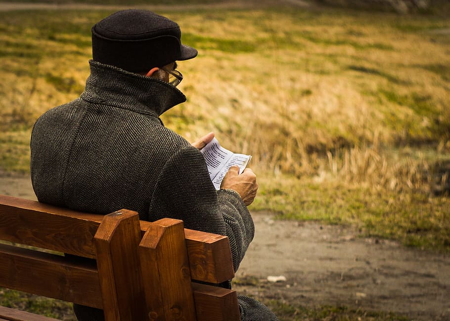 man holding paper sitting on bench, man sitting on bench while reading book HD wallpaper
