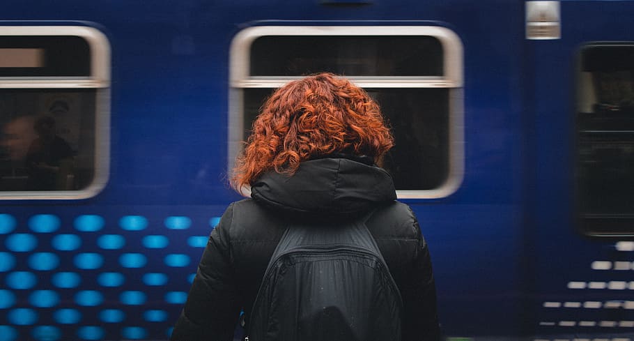 Download A Woman In A Black Jacket Standing In Front Of A Car Wallpaper