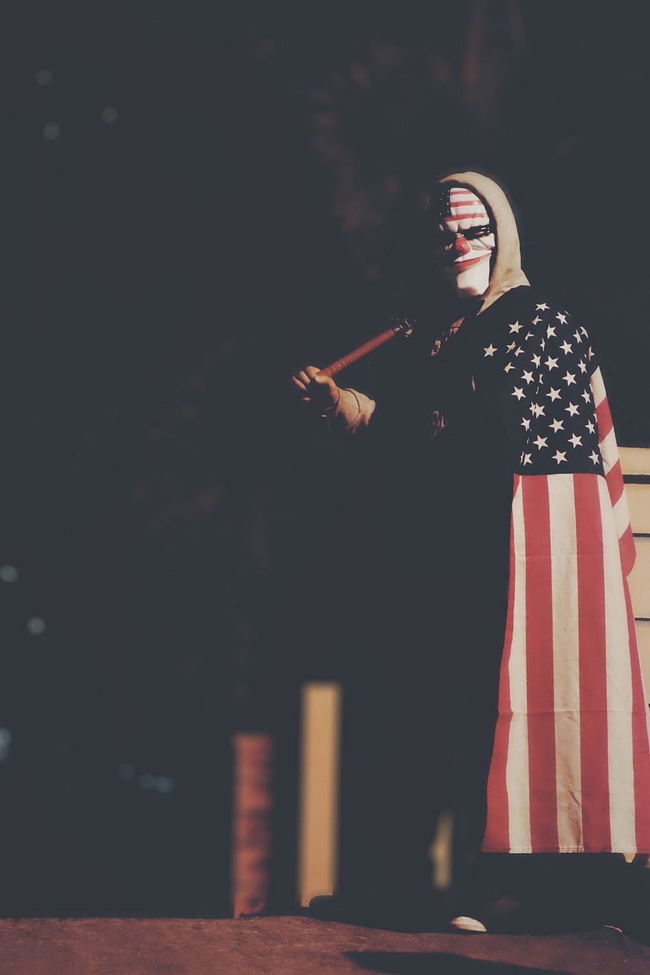 American Horror Movie, person wearing black, white, and red U.S.A. flag holding brown bat while standing at nighttime HD wallpaper