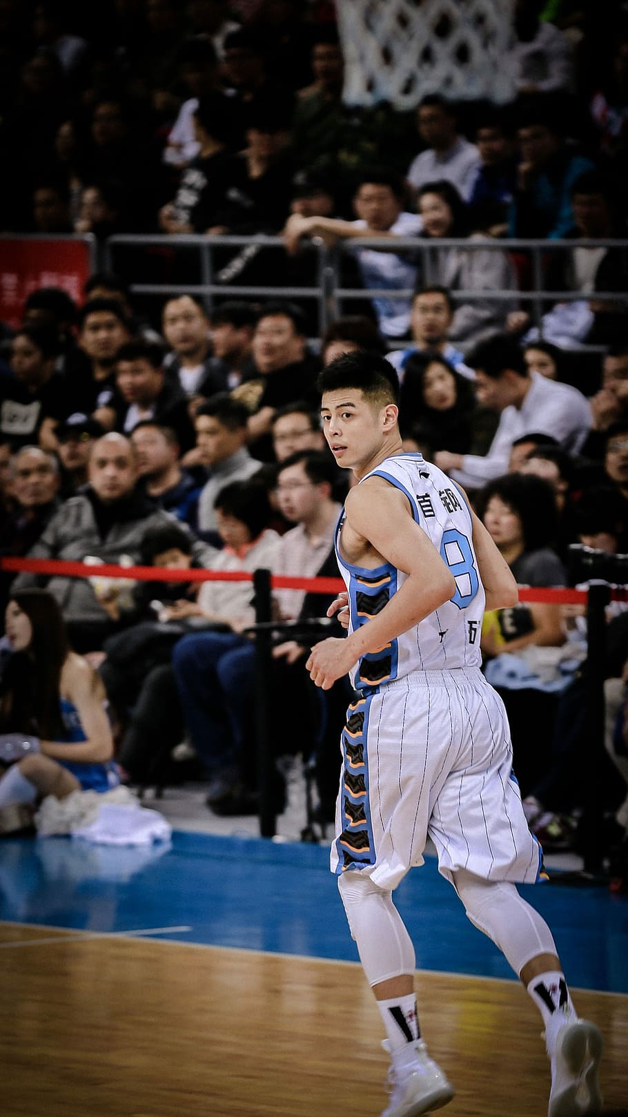 man wearing white and blue basketball jersey standing inside basketball field, man wearing white and blue basketball jersey shirt running on basketball court