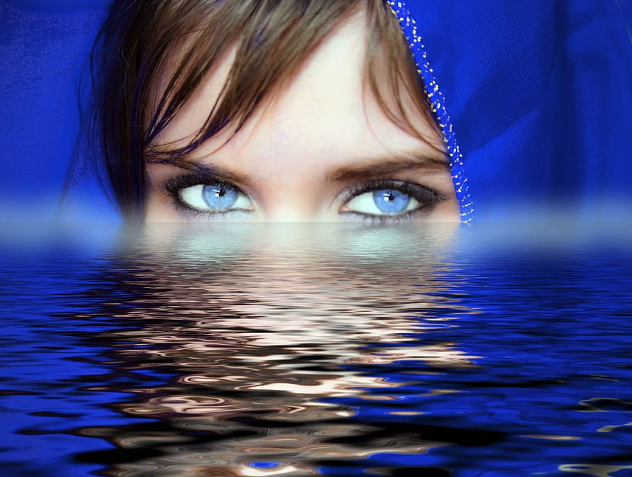 woman with blue eye lens and head scarf on body of water, blue eyes